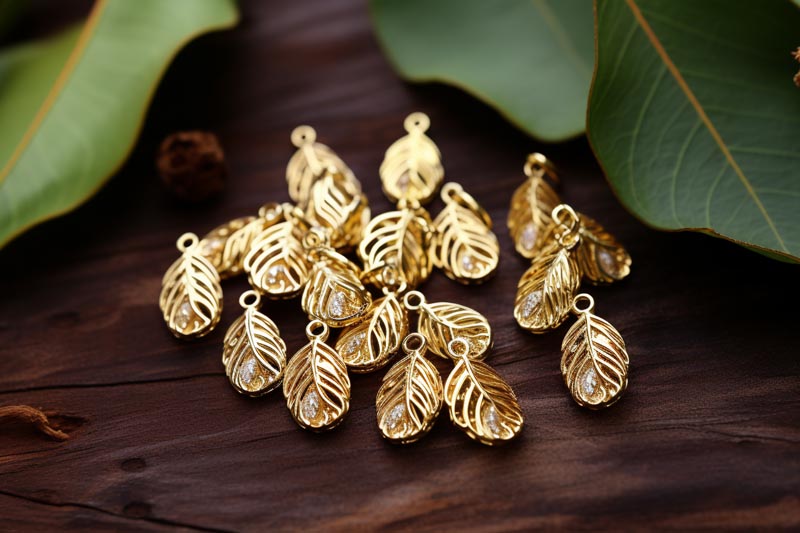 Gold filled charms in various shapes and designs, artistically arranged on a white surface